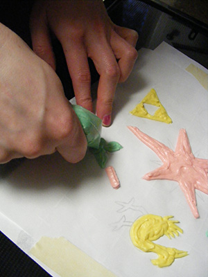 TK's hands piping butterfly on wedding cake