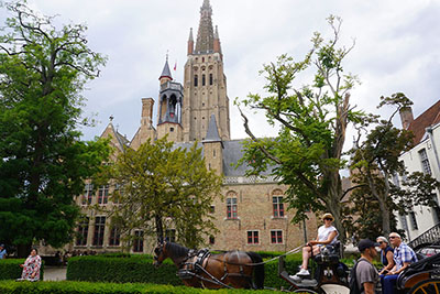 Horse-drawn carriage in front of a church in Brugge